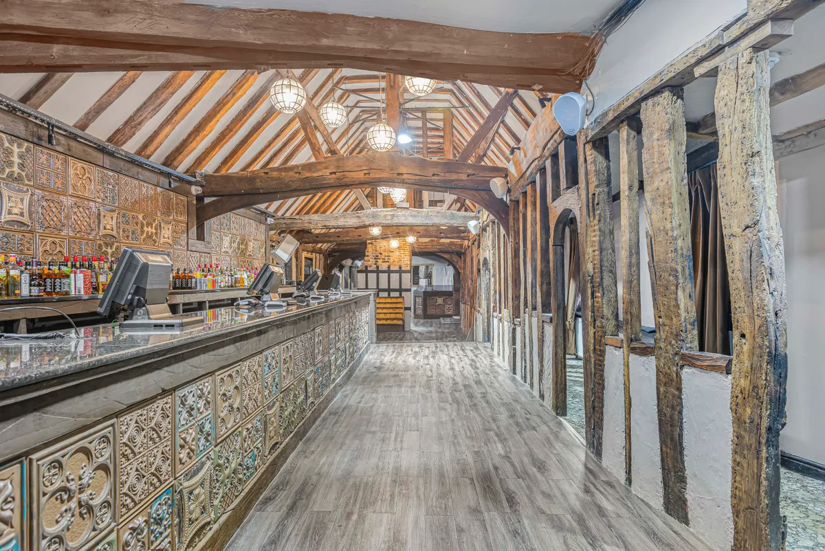 The interior of the west gallery next to the courtyard, showing original timbers and the now closed-in gallery to the right of the photo.