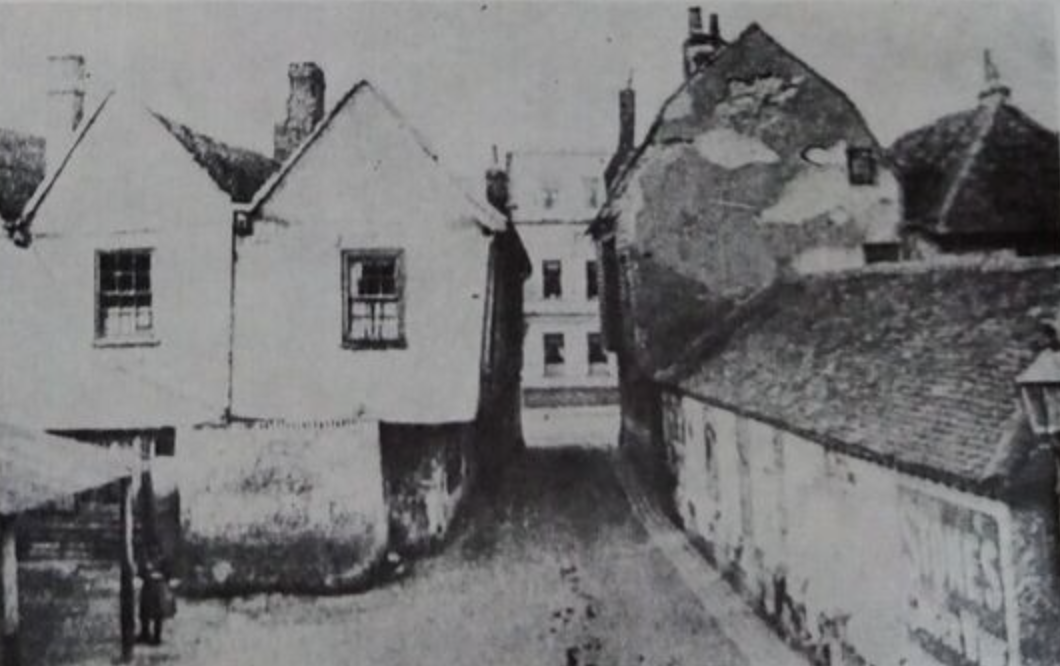 A photo showing Crown Street leading into the High Street. In the bottom left of this photo you can just see the posts and roof of one of the old permanent market stalls.
